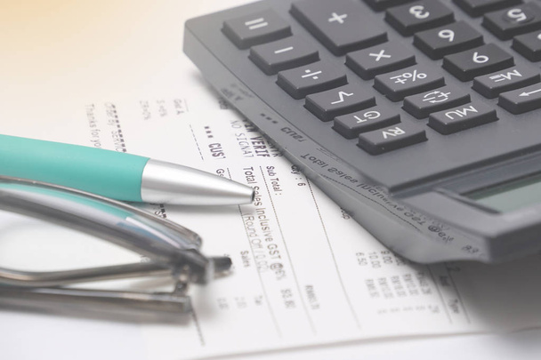 ワークステーション上の電卓、領収書、眼鏡とペン。財務および税務の概念 - 写真・画像