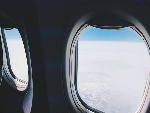 Plane window view with blue sky and clouds.   - Zdjęcie, obraz