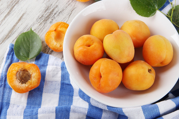 Apricots on board for cutting on napkin on wooden table - Foto, immagini
