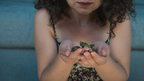 The young person are holding medical marijuana buds in his hand. - Foto, Bild