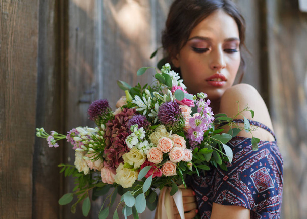 Beautiful young woman holding bouquet of flowers close up, sweet romantic moment, space for text, selective focus - Foto, Imagen