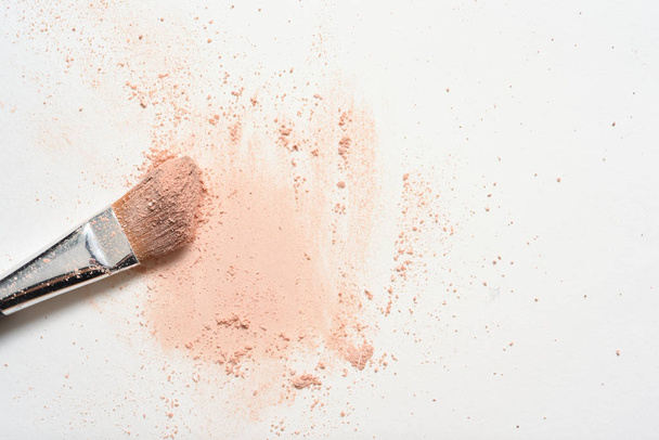rosa Make-up verschüttet über weiße Oberfläche mit Make-up-Pinsel-Bezug - Foto, Bild