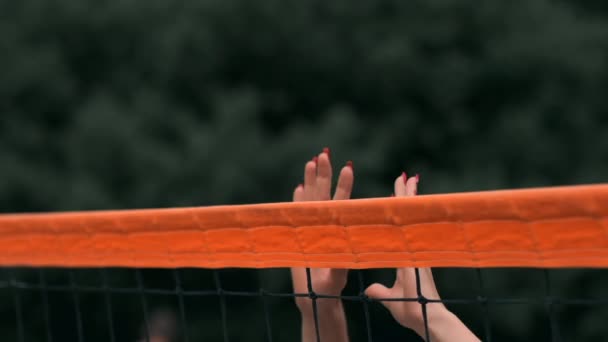 SLOW MOTION, CLOSE UP, LOW ANGLE: Unrecognizable young female hands playing volleyball at the net. Offensive player spikes the ball and the opponent blocks it right above the net during a tournament. - Footage, Video