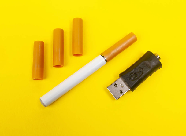 Elektronikus cigaretta sárga háttérrel. - Fotó, kép