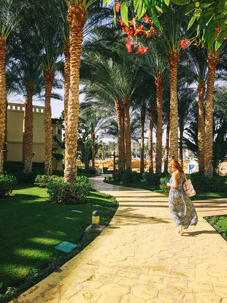 the girl is walking along the road in the resort - Photo, Image