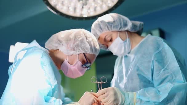 Στο χειρουργείο, δύο χειρούργοι κατά τη διάρκεια μιας επιχείρησης. Επαγγελματίες γιατροί σε ένα σύγχρονο νοσοκομείο. Πλαστική χειρουργική, σύγχρονη μιξσίνη,. επαγγελματική ομάδα γιατρών. Concept ομορφιά, υγεία. - Πλάνα, βίντεο