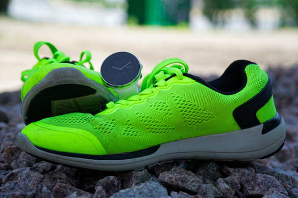 Montre de sport pour crossfit et triathlon sur les chaussures de course vertes. Montre intelligente pour suivre l'activité quotidienne et la musculation
. - Photo, image