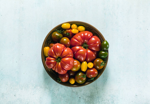 multicolored tomatoes of different colors, shapes and sizes in a - Foto, Bild