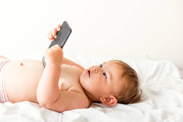 baby girl using mobile phone , browsing, copy space, gen z, watching carttons - Valokuva, kuva