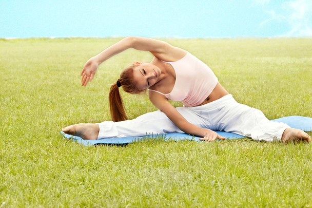 Beautiful Woman doing Stretching Exercise against Nature Backgro - Valokuva, kuva