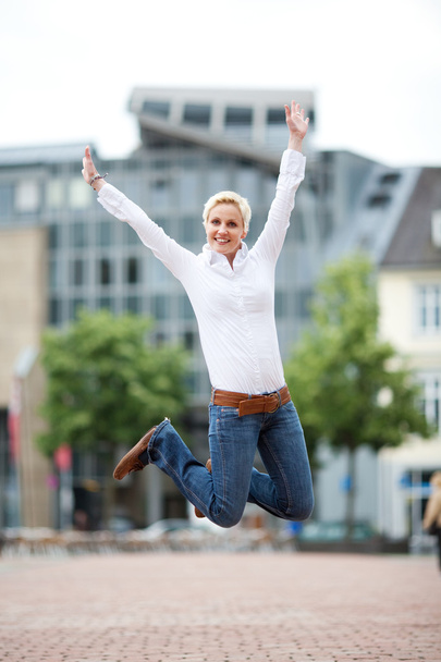 Successful woman leaping outdoors - Foto, afbeelding
