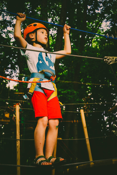 Der Junge klettert auf einen Seilpark - Foto, Bild