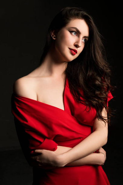 Beautiful woman in red on black background - Zdjęcie, obraz