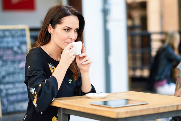 Žena středního věku konzumní kávu v městské kavárně. - Fotografie, Obrázek