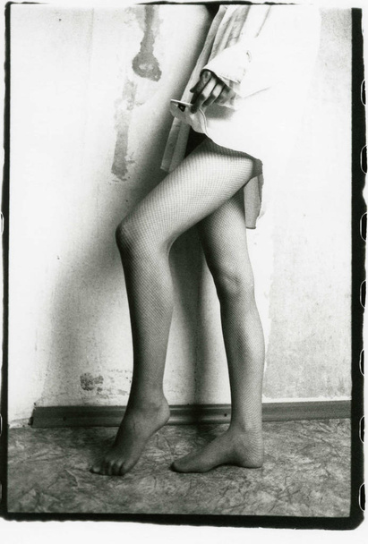 Slender female legs in mesh pantyhose, in the background of a sh - Фото, зображення