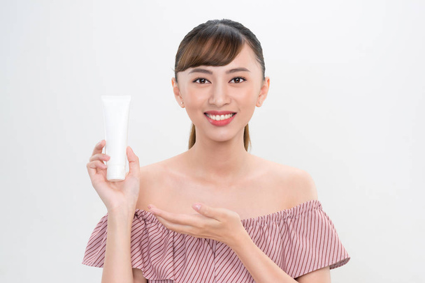 sorridente giovane donna che mostra prodotti per la cura della pelle
  - Foto, immagini