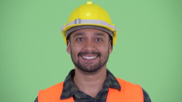 Face of happy young bearded Persian man construction worker nodding head yes - 映像、動画