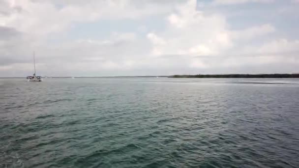 Een uitzicht op de motor van de boot en de Oceaan. Camera op een drijvende boot. Golven aan de achterkant van de boot. - Video