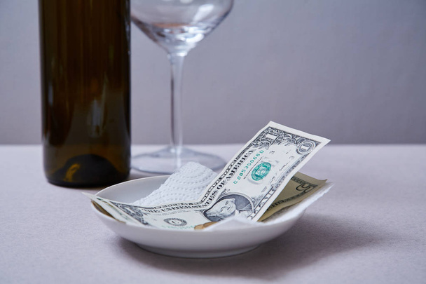 Restaurant tips or gratuity. Banknotes and coins on a plate - Foto, immagini