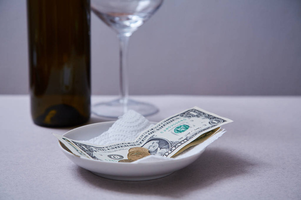 Restaurant tips or gratuity. Banknotes and coins on a plate - Foto, imagen