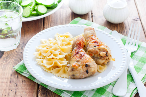 Chicken legs stuffed with champignons on a white plate with pasta, horizontal - Fotografie, Obrázek