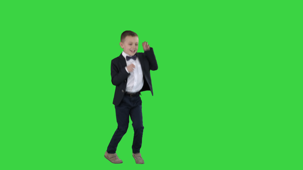 Resmi takım elbiseli sevimli bir çocuk Yeşil Ekranda bir topa vurmak, Chroma Key. - Video, Çekim