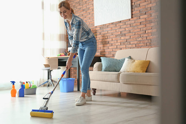 Woman cleaning floor with mop in living room - Foto, Imagen