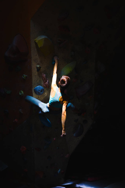 A woman is training in a climbing gym. - Фото, изображение