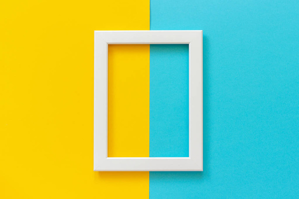 White frame on yellow and blue background. Creative Flat lay Top view Mockup Copy space for text - Foto, afbeelding
