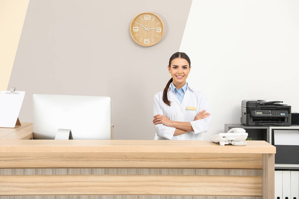 Portrait of receptionist at desk in modern clinic - 写真・画像