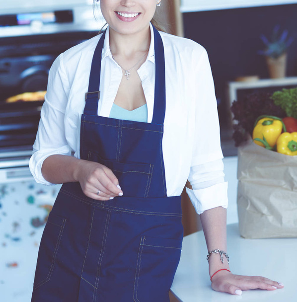 Muotokuva nuori nainen seisoo kädet ristissä vastaan keittiön tausta - Valokuva, kuva