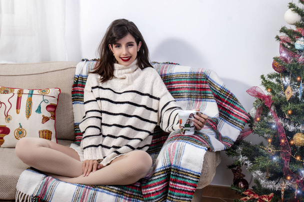 Молодая девушка на диване на Рождество
 - Фото, изображение