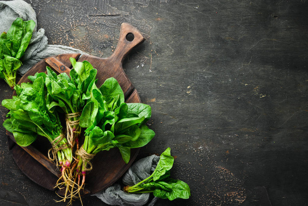 Fresh spinach on a brown background. Healthy food. Top view. Free space for your text. - Foto, imagen