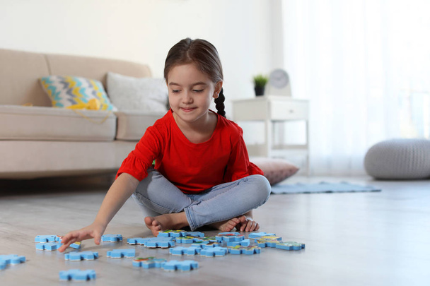 Carino bambino che gioca con i puzzle sul pavimento al chiuso. Spazio per testo
 - Foto, immagini
