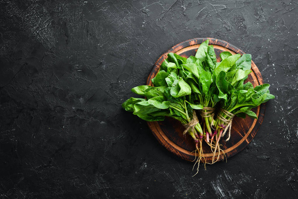 Fresh green spinach on a black stone table. Top view. Free space for your text. - Fotoğraf, Görsel