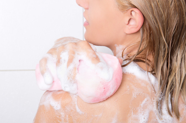 jonge mooie vrouw haar schouders wassen - Foto, afbeelding