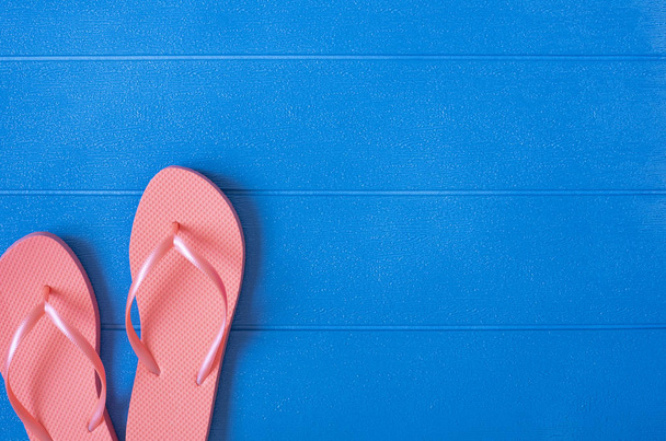 Flip flops on blue wooden background. Summer concept. Flat lay, top view, copy space - Foto, imagen