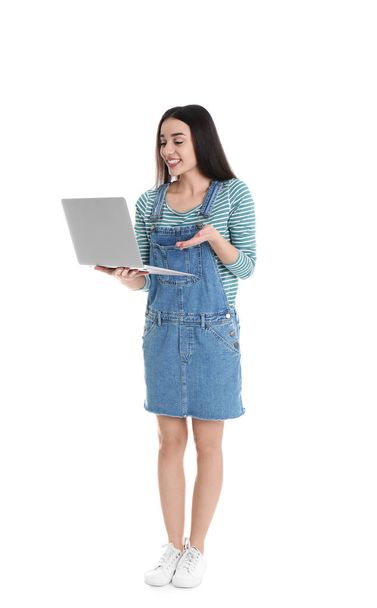 Full length portrait of young woman in casual outfit with laptop on white background - Foto, Imagem
