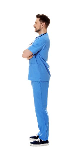 Full length portrait of smiling male doctor in scrubs isolated on white. Medical staff - Foto, immagini