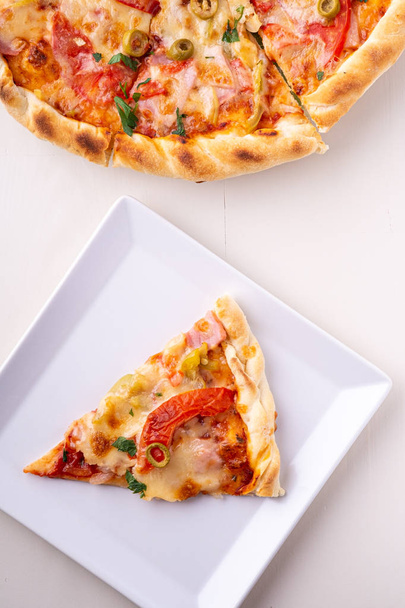 Egyetlen pizza szelet a fehér lemez és az egész pizza fa háttér felülnézet - Fotó, kép