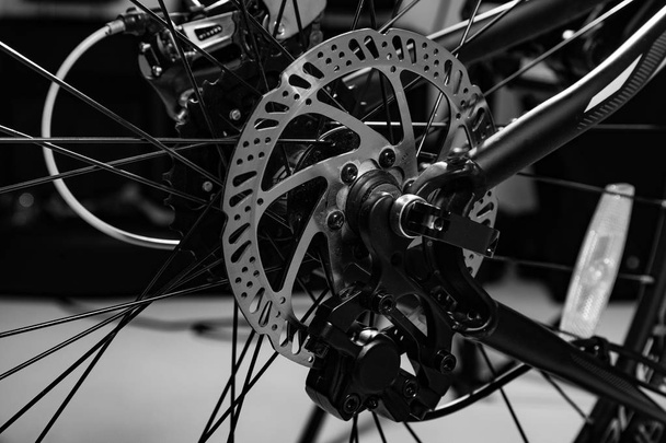 close-up shot of named mechanic brake disc on bicycle in black and white - Photo, Image