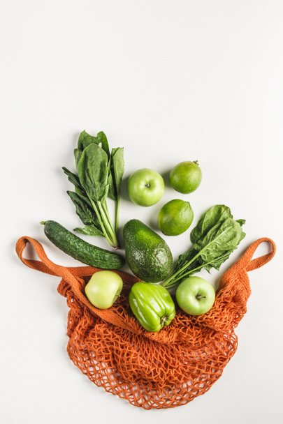Légumes et fruits verts dans un sac à ficelle orange
 - Photo, image