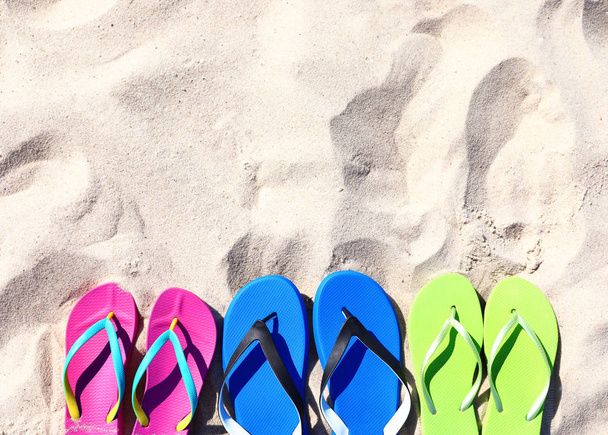 Flat lay composition with flip flops on sand in summer, space for text. Beach accessories - Foto, Imagem