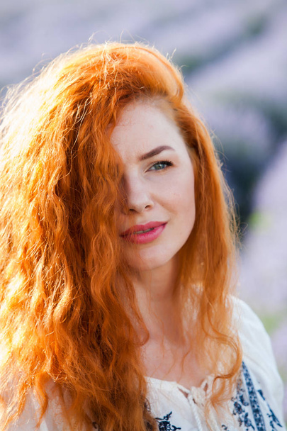 Летний портрет красивой девушки с длинными вьющимися рыжими волосами. женщина с длинными волосами. Европейская девушка в лавандовом поле
. - Фото, изображение