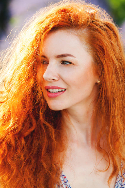 Retrato de verão de uma menina bonita com cabelo vermelho encaracolado longo. mulher com cabelo comprido. Menina europeia no campo de lavander
. - Foto, Imagem