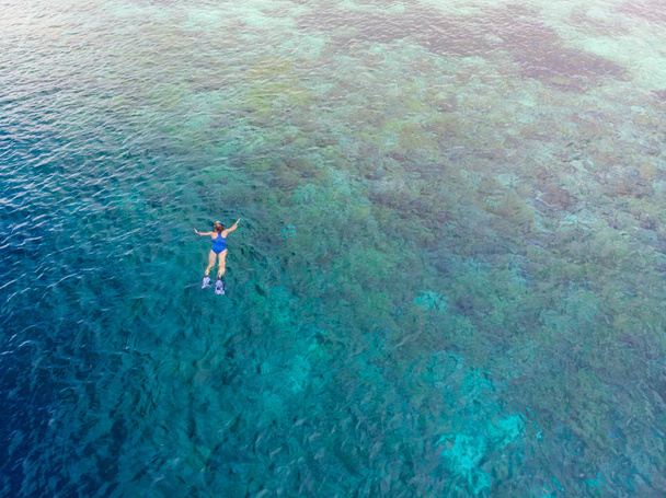 Levegőtől lefelé búvárkodó emberek a korallzátonyon, trópusi karibi tenger, türkiz kék víz. Indonézia Wakatobi szigetcsoport, tengeri nemzeti park, turisztikai búvárkodás úticél - Fotó, kép