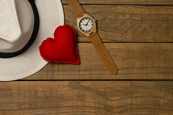 Set of elegant male accessories, men's fashion. Watch, panama hat and fabric heart on rustic wooden background. The concept of father's day card, copy space for text. - Photo, Image