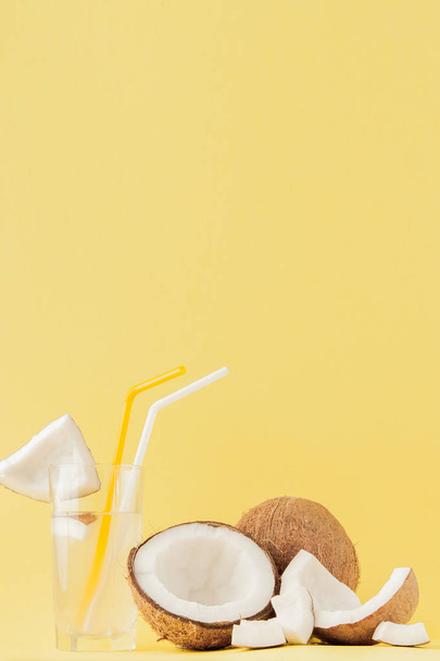Fresh Coconut cocktail with a straws on yellow background, copy  - Fotoğraf, Görsel