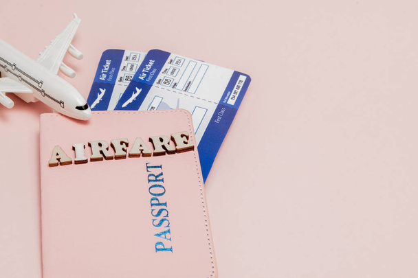 Inscription "airfare", Airplane, air ticket and money on a pink  - Foto, Bild