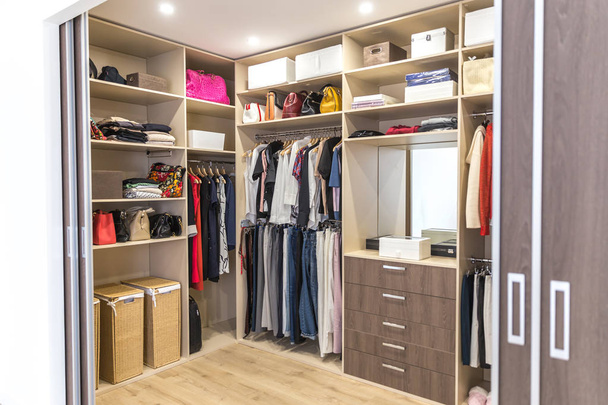 Big wardrobe with different clothes for dressing room - Photo, Image